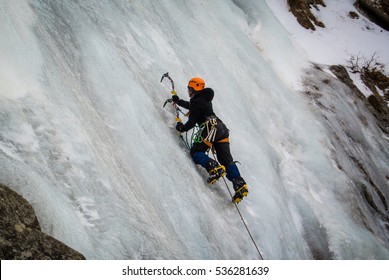 Ice Climber On Steep Frozen Waterfall

