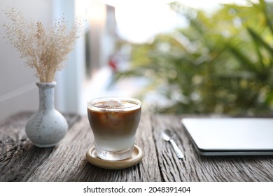 Ice Coffee And Dry Grass Flower On Wooden Table