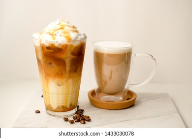 Ice Coffee In The Glass Topped Whipping Cream With Coffee Beans. Cold Summer Drink On Wooden Background And Copy Space. Advertising For Caramel Mocha And Chocolate Beverage For The Cafe.