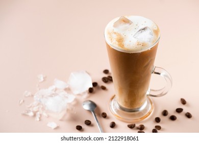Ice Coffee Latte In Glass In Beige Background. Refreshing Summer Drink