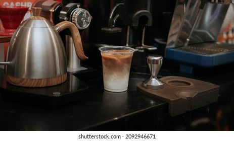 Ice Coffee And Milk In An Espresso Machine With A Barista Set Up Behind The Grinder Mechine And Cattle