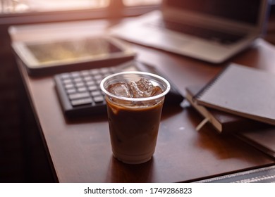 Ice Coffee On Office Workplace With Laptop, Calculator, Book And Document On Wood Table