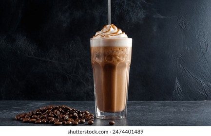 Ice coffee in a tall glass with cream poured over, ice cubes and beans on a dark concrete table. - Powered by Shutterstock