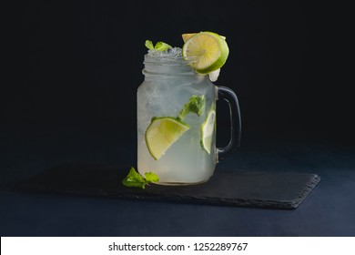 Ice cold classic lime lemonade in a vintage glass mason jar. Dark background with copy space for a menu. - Powered by Shutterstock