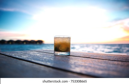 ice cold cocktail in a beach bar on the maldives at sunset - Powered by Shutterstock