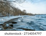 Ice Cold Winter Waves Lapping up on a Snow Covered Icy Beach 
