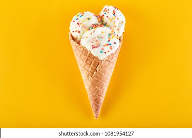 Ice Cream Balls With Colored Sugar Sprinkles In A Waffle Cone On A Yellow Background. Vanilla Ice Cream In A Waffle Cone.