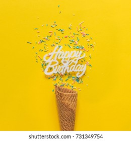 An Ice Cream Cone And Confetti For Happy Birthday Party. Minimal Flat Lay