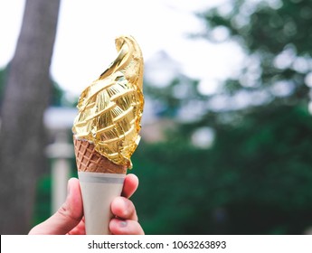 Ice Cream Cone Covered With Real Gold Leaf Held By Hand