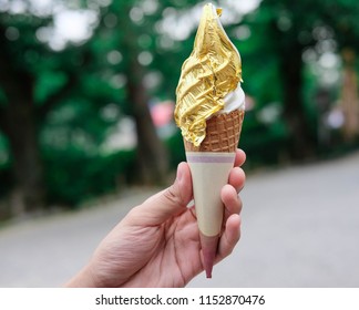 Ice Cream Cone Covered With Real Gold Leaf Held By Hand