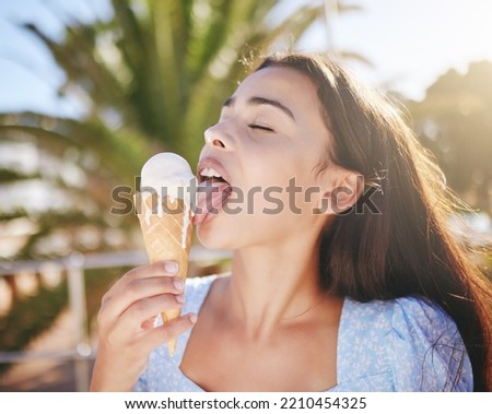 Ice cream cone eating, woman and summer dessert to enjoy on vacation, holiday and relaxing weekend in Portugal. Happy young girl licking melting gelato icecream outdoors for cool, fun and sweet snack