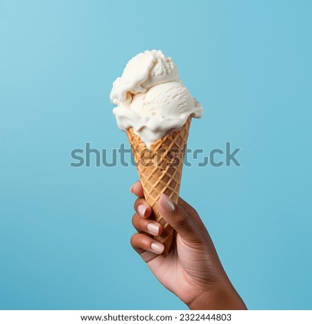 Ice cream cone on a blue background. The woman holding the ice cream by hand.

