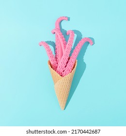 Ice Cream Cone With Pink Octopus Tentacles With Sunny Day Shadows On Bright Blue Background. Minimal Vacation Concept. Trendy Sea Or Ocean Flat Lay. Summer Food Surreal Idea.