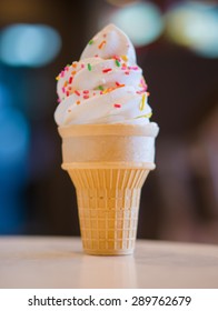 Ice Cream Cone With Rainbow Color Sprinkles On Blurry Background