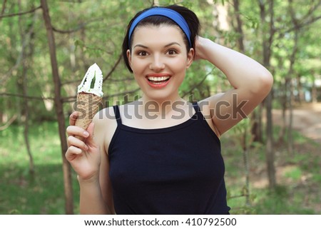 Ice cream. Cute woman with ice cream in hand. Tasty dessert. Wafer cup. Straight teeth.