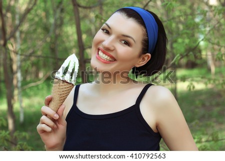 Ice cream. Cute woman with ice cream in hand. Tasty dessert. Wafer cup. Straight teeth.