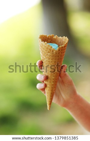ice cream horn in a woman's hand. Delicious ice cream melts and flows to the horn in the woman's hand