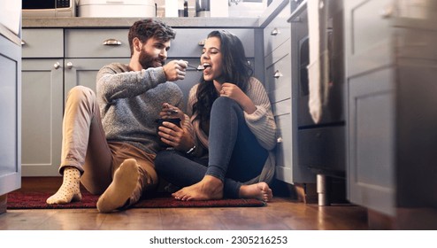 Ice cream, kitchen and couple on floor in home for bonding, relaxing and quality time together. Love, relationship and happy man and woman with sweet treats, dessert and luxury snack for romance - Powered by Shutterstock