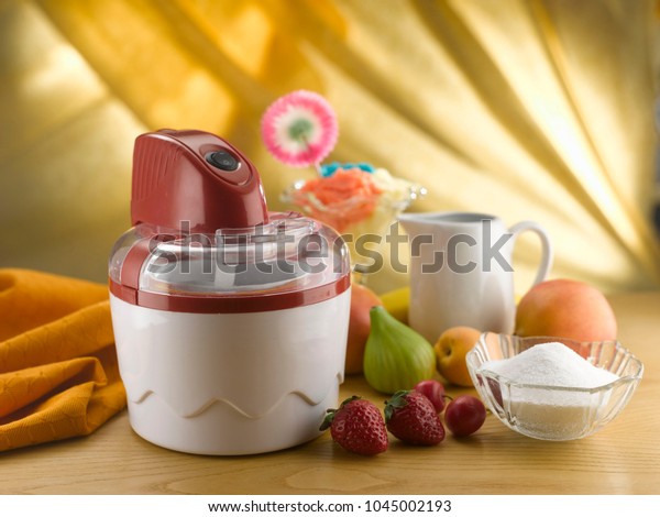 ice cream maker\
and fruit on a kitchen\
shelf