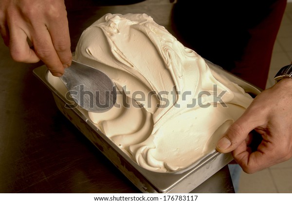 Ice cream maker\
scooping a vanilla flavor.