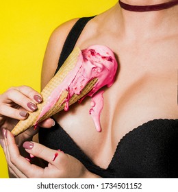 Ice cream melts on the girl's chest.The background is yellow. Pink ice cream in a waffle cone. Clothes are black. The open neckline. There is a red ribbon around her neck. Food and women's Breasts.