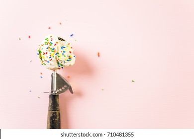 Ice Cream Scoop With Vanilla Ice Cream With Rainbow Sprinkles On Pink Background.