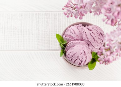 Ice Cream Sundae Bowl And Lilac Flowers. With Copy Space