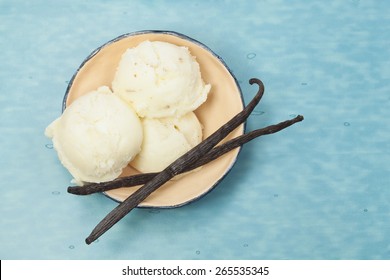 Ice Cream. Vanilla ice cream in rustic bowl on blue table. Top view. Macro, selective focus