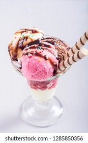 Ice creeam in sundae . Chocolate , vanilla and strawberry