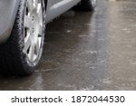 Ice crusted ground, car wheel on icy road, hazardous weather conditions, winter street