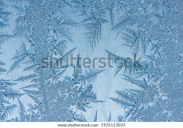 Ice crystals in the detail on a window glass in\
winter time