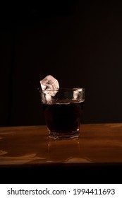 An Ice Cube Captured A Split Second Before It Hits The Drink.