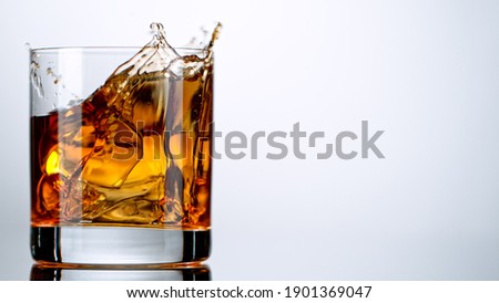 Ice Cube falling into Glass of Whisky, Freeze Motion.