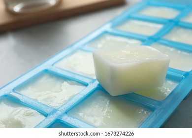 Ice Cube Tray With Frozen Milk On Grey Table, Closeup