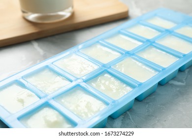 Ice Cube Tray With Frozen Milk On Grey Table, Closeup