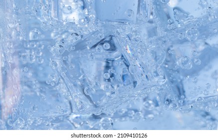 Ice Cubes With Air Bubbles Swirl Around In The Glass. Soda Water And Cool In A Clear Glass.