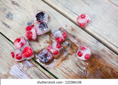 Ice Cubes With Blueberry And Red Currant Berry Inside On Wooden Table In Summer