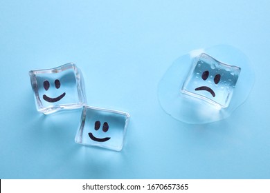 Ice cubes with drawn faces on light blue background, flat lay. Concept of jealousy - Shutterstock ID 1670657365
