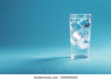 Ice Cubes In A Glass With Crystal Clear Water On A Blue Background. Refreshing And Healthy Water On Hot Days