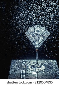 ice cubes are not a dark table. martini glasses on dark background. martini ice on a dark table. martini glasses and water splashes. water drops and martini on dark background