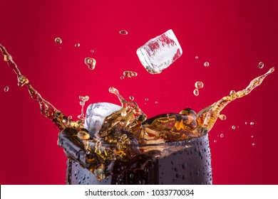 Ice cubes splashing into cola drink