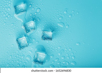 Ice Cubes With Water Drops Scattered On A Blue Background, Top View.