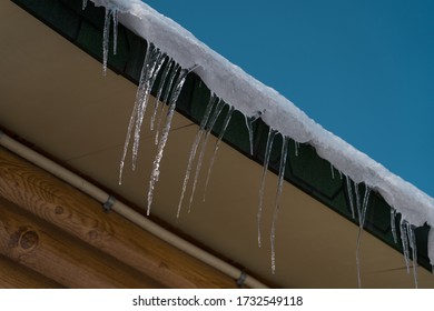 Ice Dams On House Roof. Heavy Snow Stacked On The Roof