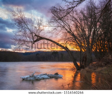 An ice drift floats on the Susquehanna River in New York State just after the sun set below the horizon to end a winter day.  