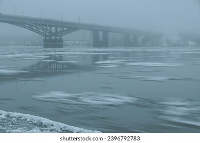 ice drift, freeze-up, on the Siberian Irtysh River in the city of Omsk. Early winter. view of the bridge 60 years of the Komsomol