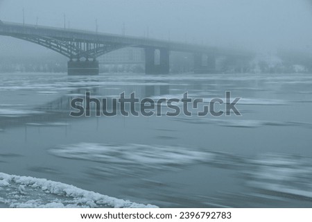 ice drift, freeze-up, on the Siberian Irtysh River in the city of Omsk. Early winter. view of the bridge 60 years of the Komsomol