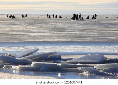 Ice Fishing Anglers On Ice And Beautiful Yellow Sunset In Pärnu Bay, Baltic Sea, Estonia