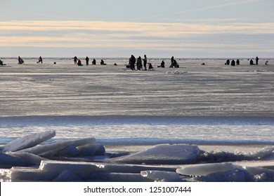 Ice Fishing Anglers On Ice And Beautiful Yellow Sunset In Pärnu Bay, Baltic Sea, Estonia