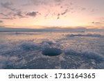 Ice fishing hole at frozen sea in the north.