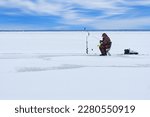 Ice fishing. lonely man fishing for perch. Winter fishing as hobby, Winter activity in Scandinavia. Hobby, winter free time concept